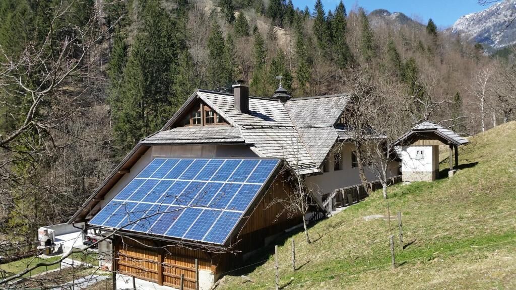Ein Haus mit geneigtem Dach und Solaranlage an der Vorderseite.