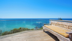 A wooden deck with a bench overlooking a clear blue sea. - Fairwinds Manyana Stunning Views (Manyana)
