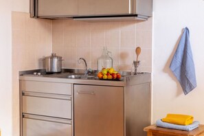 A kitchen with stainless steel appliances, a sink, and a fruit bowl on the counter. - Il Gabbiano Maremma Superior Cottage 4 PAX (Grosseto)