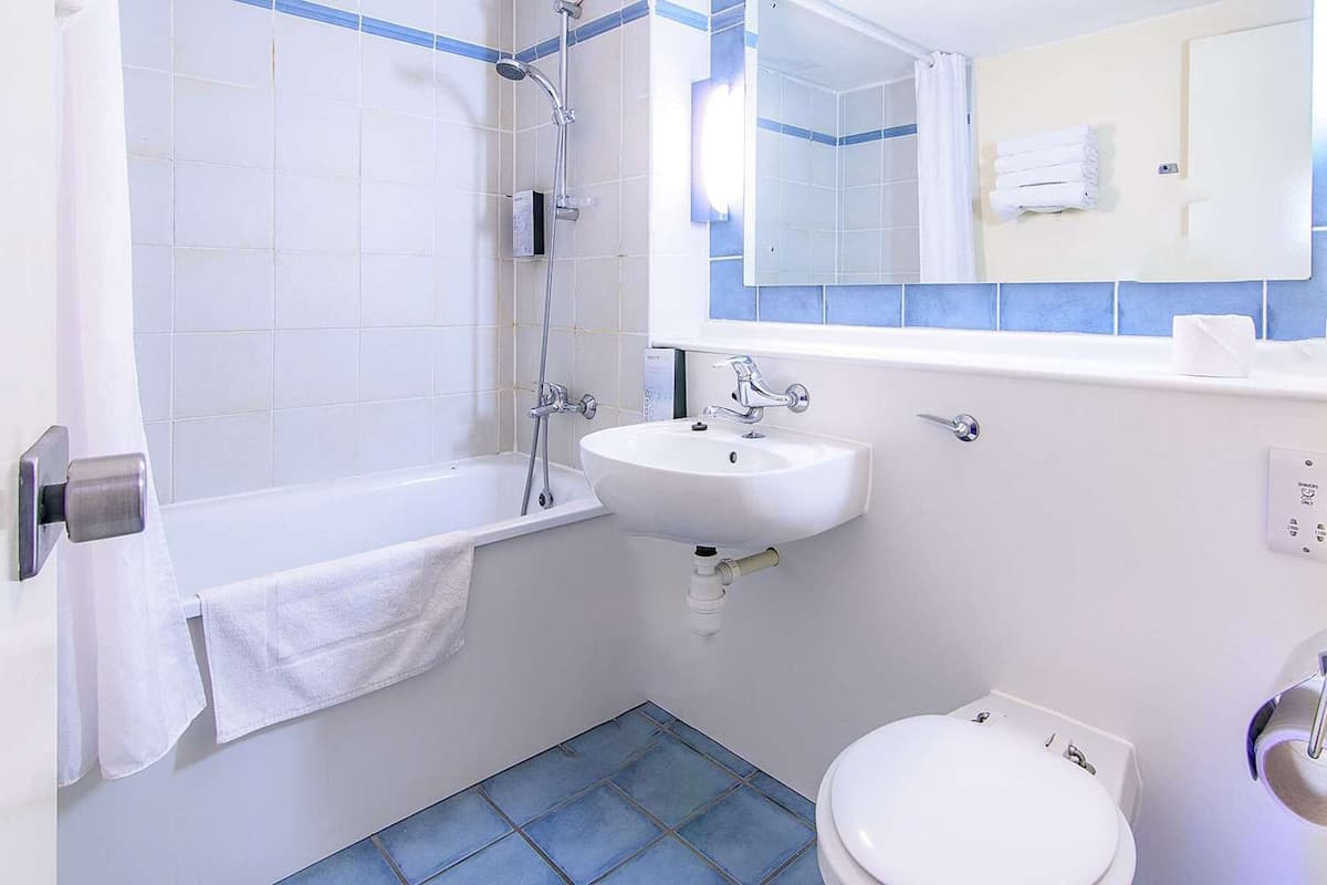 Un baño con bañera, lavamanos e inodoro.