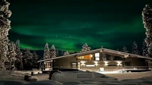 Un chalet à deux étages doté d’un porche abrité et surplombant un paysage enneigé.