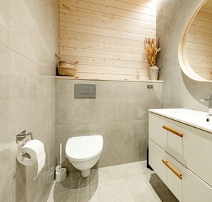 Ein modernes Badezimmer mit Toilette, Waschbecken und Waschtisch.