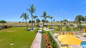 Ein Resort mit Poolbereich, Palmen und freiem Blick auf den Strand.