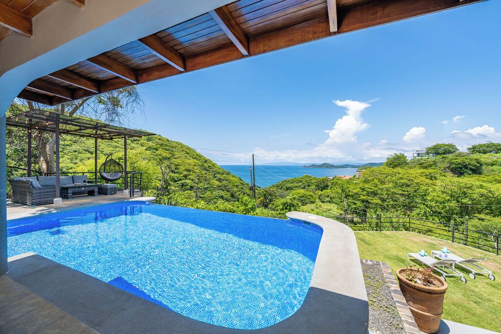 Une piscine offrant une vue sur un paysage verdoyant et luxuriant ainsi que sur la mer.