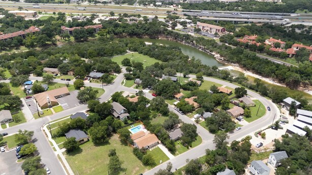 Vista aérea de una zona residencial con casas, calles y un río.