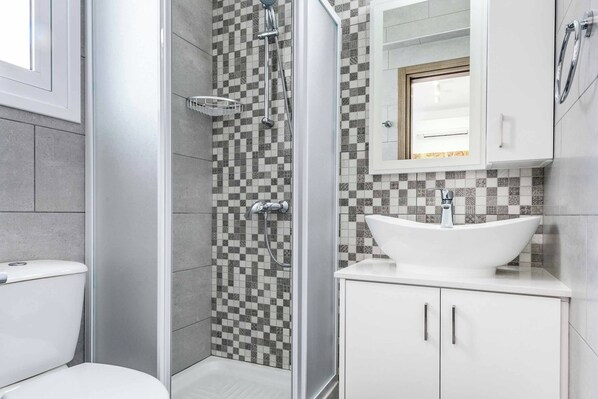 Une salle de bain moderne équipée d’une douche, de toilettes et d’un lavabo.