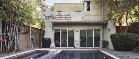 A modern building with a pool, large glass doors, and a sign that reads "BREEZE."