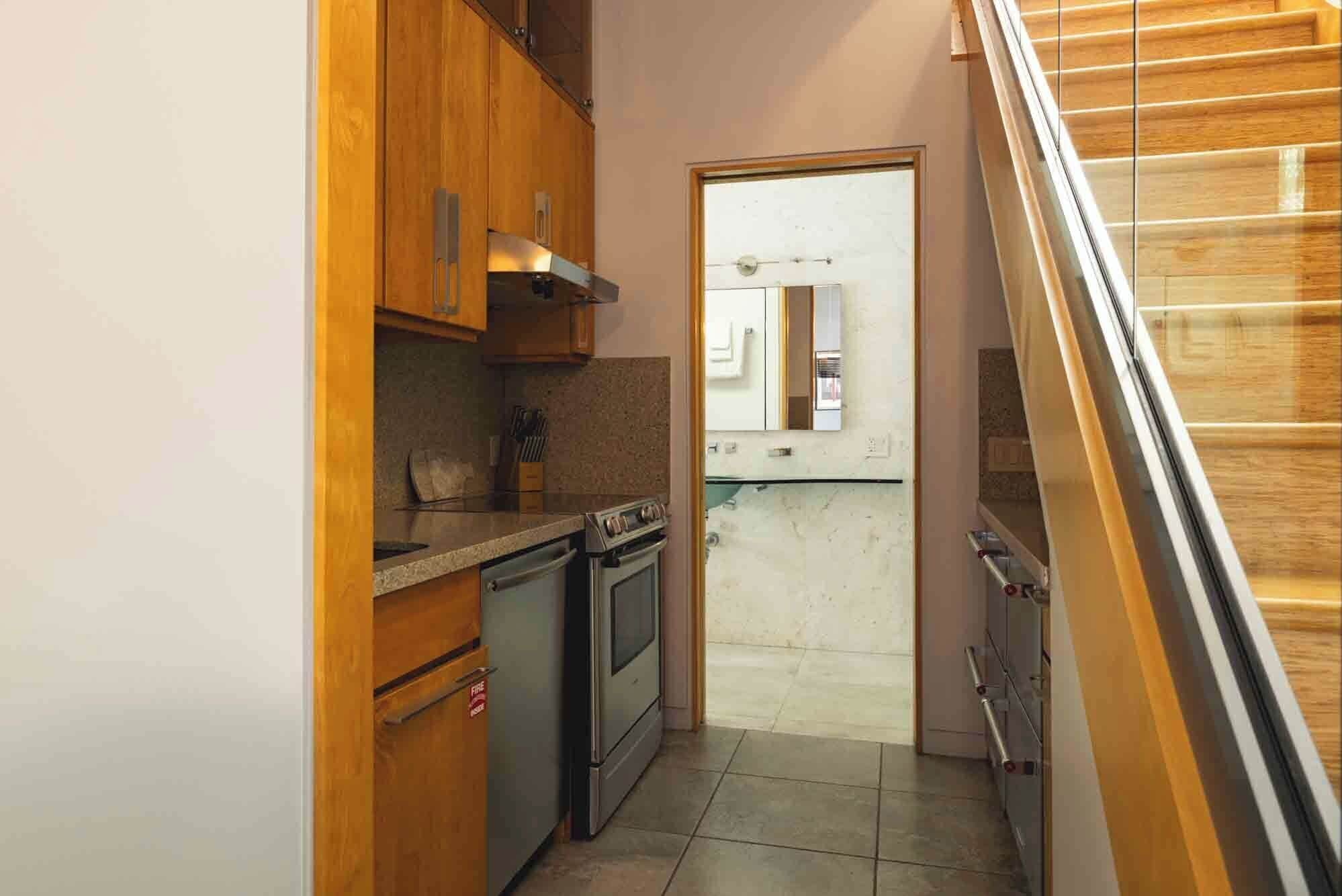Una cocina funcional con armarios de madera, estufa y una pequeña encimera.