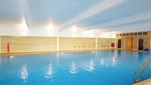 An indoor swimming pool with clear water, tiled walls, and a bench along the side. - Freshwater Beach Holiday Park - Holiday Accommodation 17116 (Bridport)