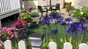 A backyard with a patio area, outdoor seating, and various potted plants. - Freshwater Beach Holiday Park - Holiday Accommodation 17116 (Bridport)