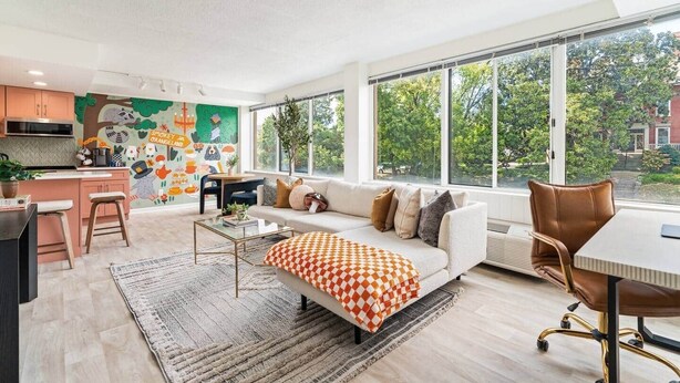 Una sala de estar moderna con sofá, mesa de centro y vistas al exterior.