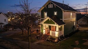 A two-story house with a porch, a visible chimney, and a small yard.