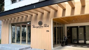 A building entrance with a wooden facade, glass doors, and a motorcycle parked outside. - Ibirapuera Park (São Paulo)