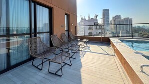 A rooftop terrace with a pool, sun loungers, and a city view. - Ibirapuera Park (São Paulo)