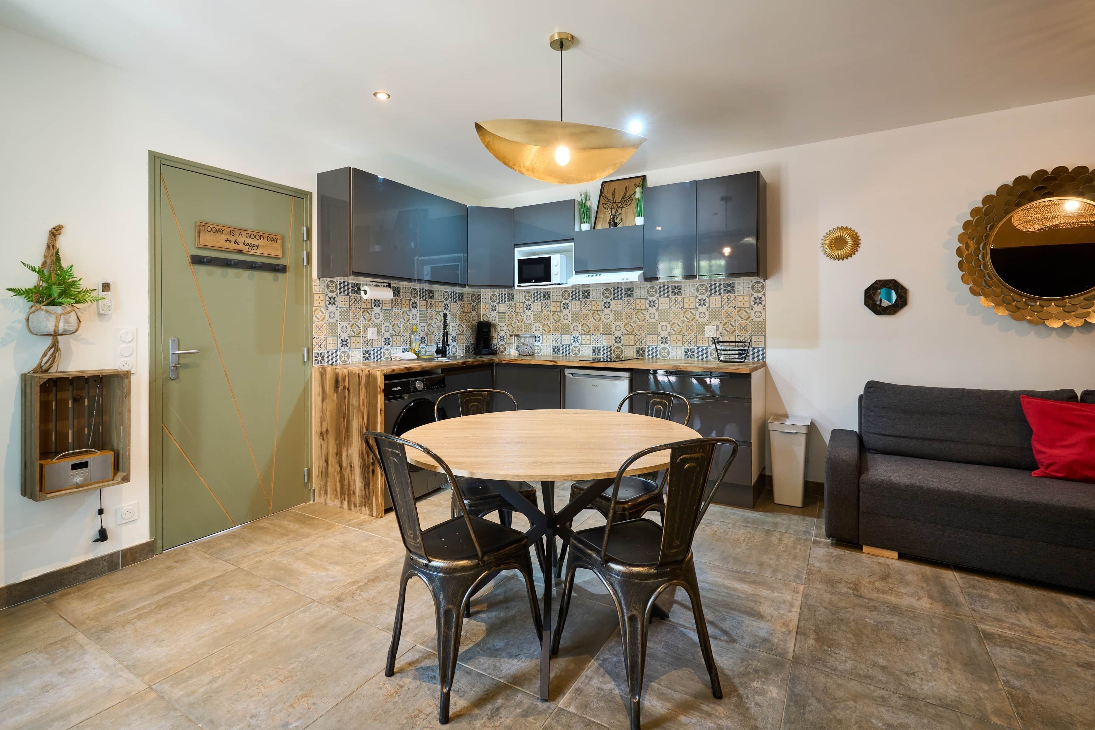Una cocina compacta con comedor, horno empotrado y microondas.