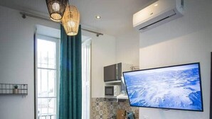 Una cocina moderna con un televisor de pantalla plana grande, una encimera de madera y dos taburetes verdes.