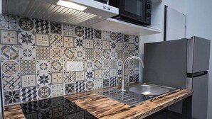 A modern kitchen with a patterned backsplash, a stainless steel sink, and a wooden countertop. - T2 with jacuzzi and terrace (Carcassonne)