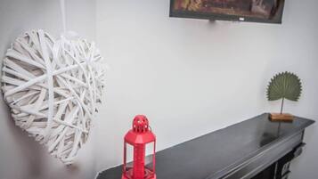 A room with a black table, a red lantern, and decorative items on the wall.