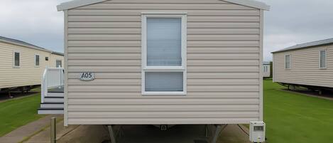 A single-story mobile home with a front entrance and a window.