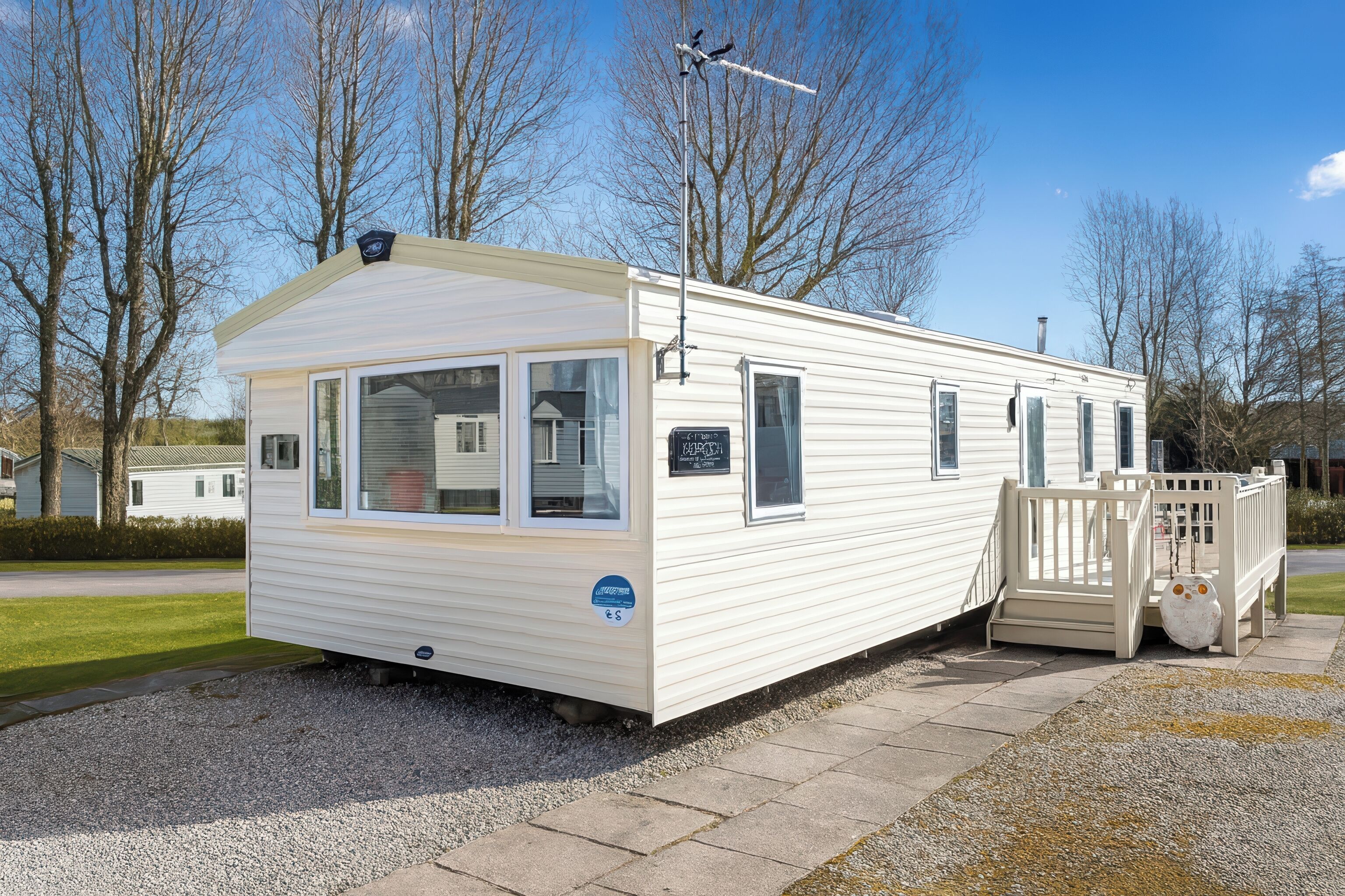 Een gelijkvloerse stacaravan met een voortuin en een klein terras.