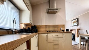 A modern kitchen with wooden countertops, stainless steel appliances, and a central island with drawers. - Thornwick Bay Holiday Village - 20633 (Bridlington)