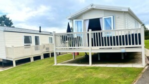 A mobile home with a balcony and a fenced deck area. - Thornwick Bay Holiday Village - 20633 (Bridlington)