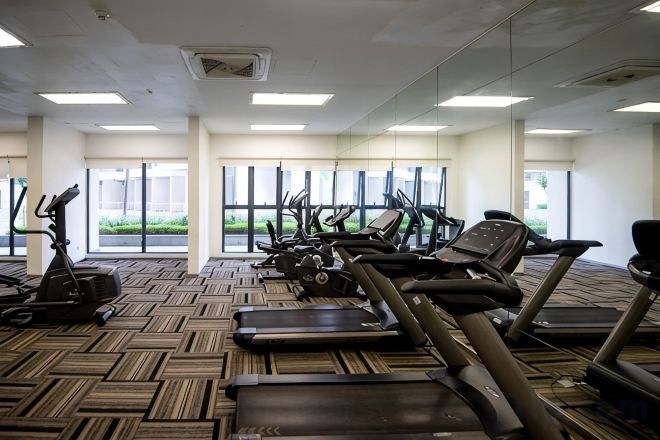 A gym with treadmills, elliptical machines, and stationary bikes.