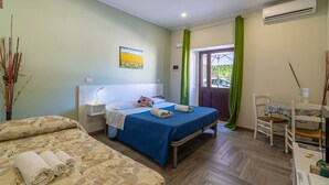 Ein Hotelzimmer mit Bett, Schreibtisch, Stuhl, einem Gemälde und Blick nach draußen.
