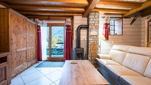 Ein Holzinnenraum mit einer Couch, einem Tisch und einem Kamin.