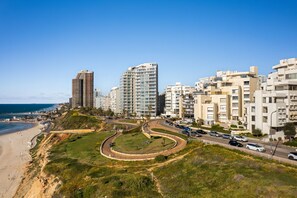 Eine Küstenlandschaft mit modernen Hochhäusern, einer gewundenen Straße und einem Strand.