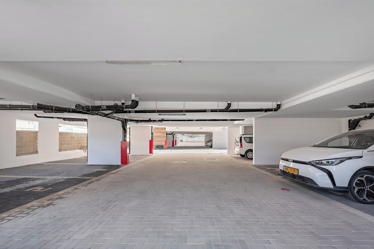 Eine saubere, moderne Parkgarage im Innenbereich, mit einem weißen Auto auf der rechten Seite.