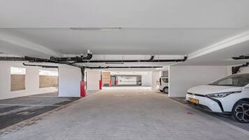 Eine saubere, moderne Parkgarage im Innenbereich, mit einem weißen Auto auf der rechten Seite.
