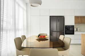 Una cucina moderna con un frigorifero nero, un fornello e un tavolo da pranzo con sedie.