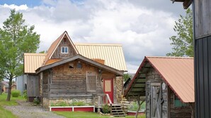 A rustic wooden building with a red door and a small porch. - CC62-Davis Cottage, Walk to shops! Firepit! Pets Ok! A/C (Davis)