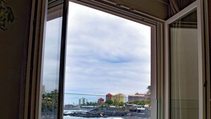 Una habitación con un gran ventanal corredero que da a una vista de la playa.