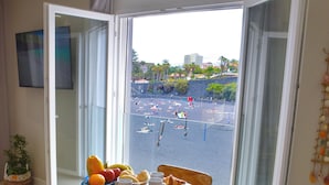 Un comedor con una mesa lista para el desayuno, vistas a una playa y una planta en maceta.