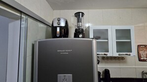 A kitchen with a refrigerator, a coffee maker, and a blender on top. - Beautiful Apartment Near VG Shopping Mall (Várzea Grande)