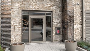 A building entrance with a glass door labeled "DRAYCOTE HOUSE". - Stylish One-Bedroom Haven (London)