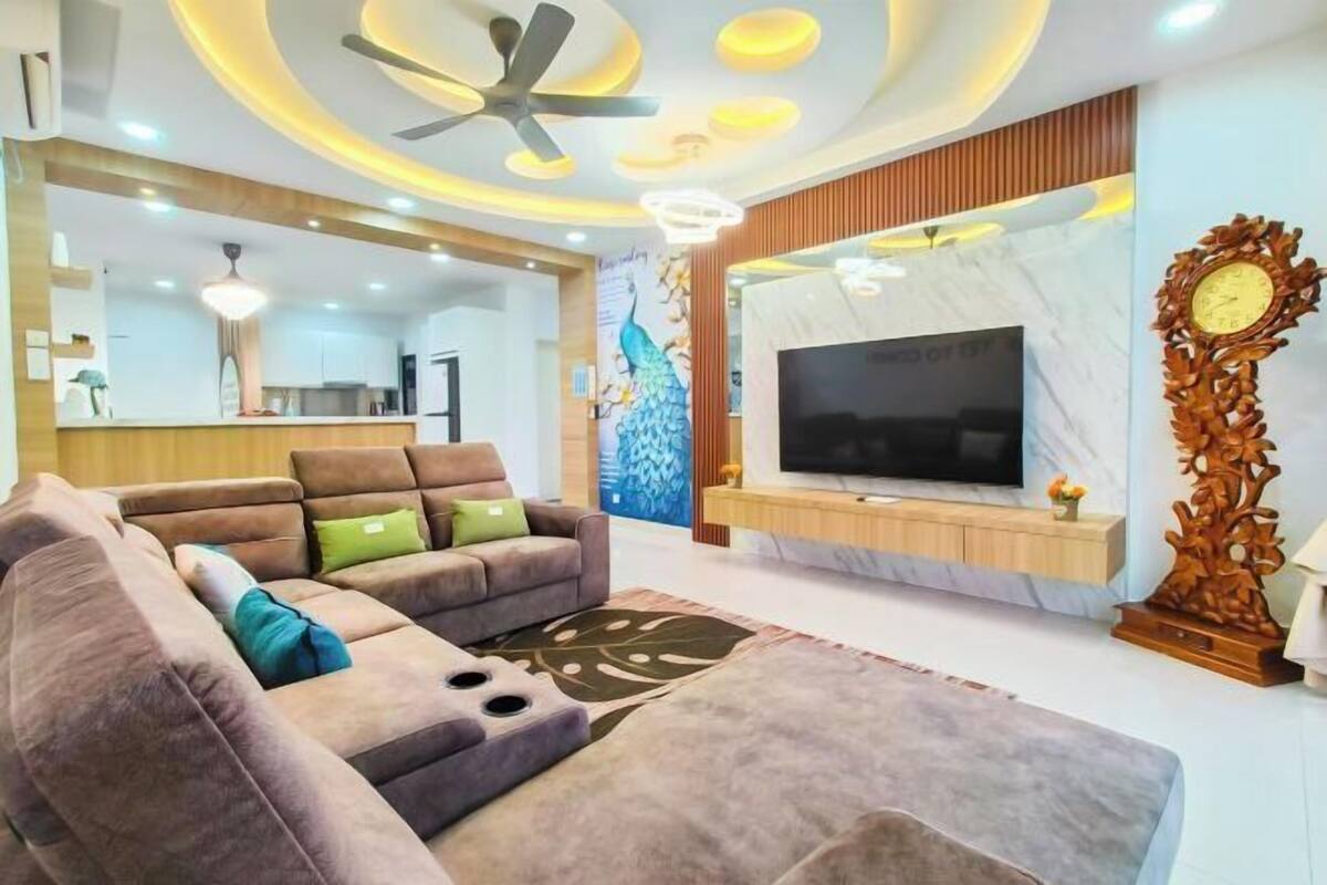 Una sala de estar moderna con un sofá seccional, un televisor de pantalla plana y un ventilador de techo.