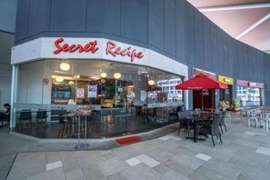 A restaurant named 'Secret Recipe' with outdoor seating and a red umbrella. - Pangsapuri Meridian by RR JBcity (Iskandar Puteri)