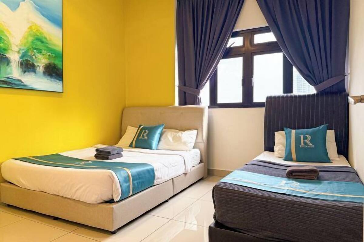 Habitación de hotel con dos camas, un cuadro grande en la pared y una ventana con cortinas.