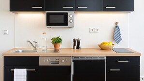 A modern kitchen with black cabinets, a microwave, a sink, and a dishwasher. - Fischerstübchen (7) Dat Fischerhuus Between the Baltic Sea and directly at the harbor (Pruchten)
