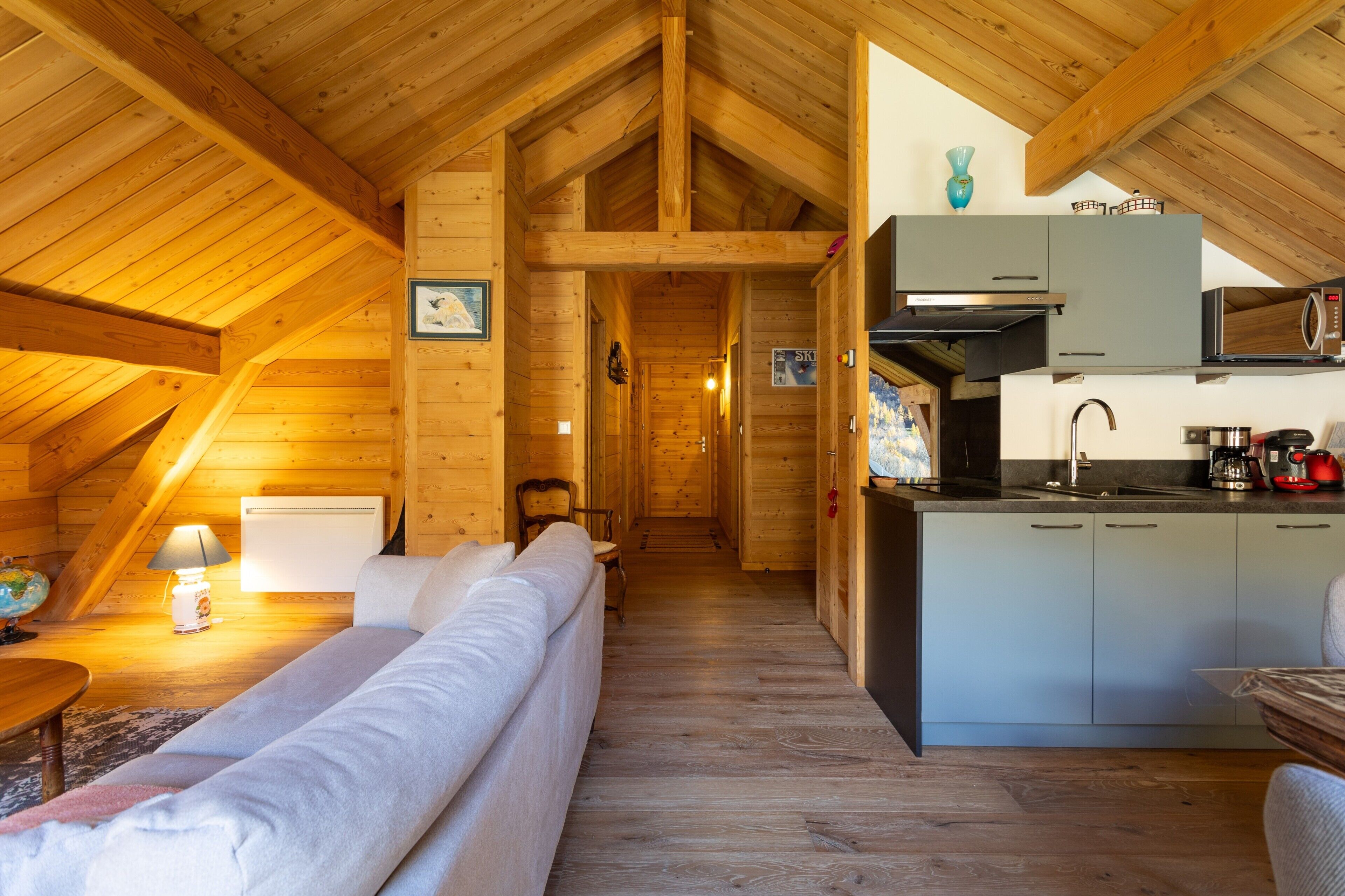 Un intérieur en bois comprenant un canapé, une table à manger et un coin cuisine.