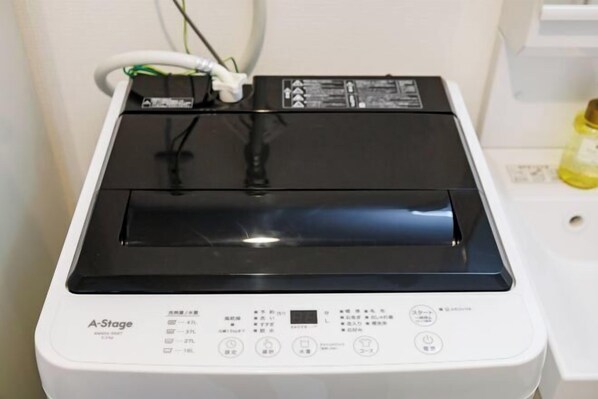 A compact, white A-Stage washing machine with a control panel and a power cord.