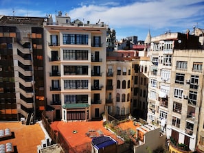 A multi-story building with balconies, a rooftop terrace, and a traditional architectural style.