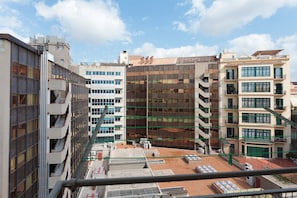 A multi-story building with a modern architectural design, featuring a glass facade and a rooftop terrace.
