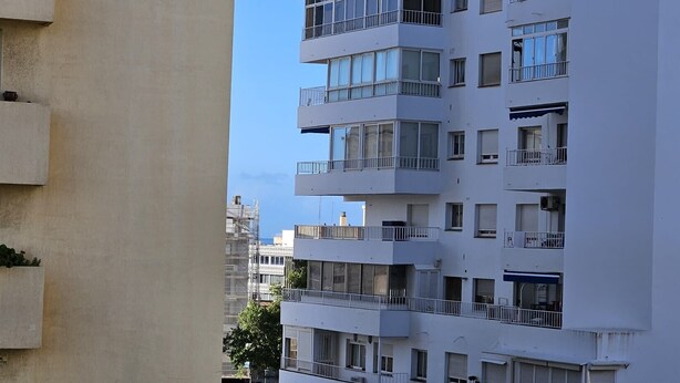 A multi-story residential building with balconies, large windows, and a clear sky. - Holiday Home 'Centrico Piso En Marbella' with Private Terrace and Wi-Fi (Marbella)