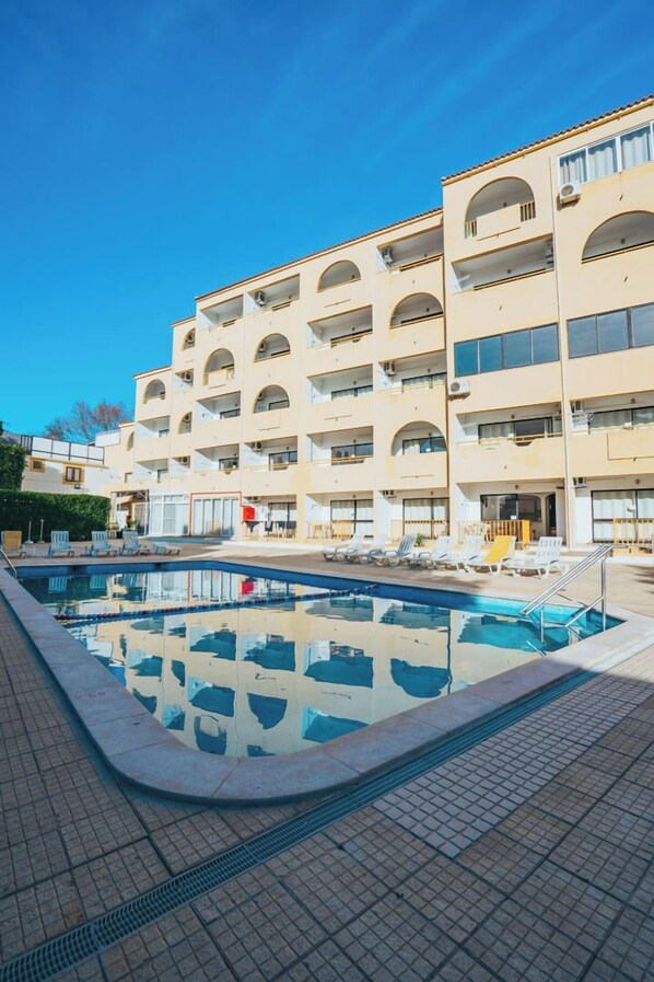 A multi-story hotel with a swimming pool, balconies, and a tiled walkway. - EiraSol by Umbral (Albufeira)