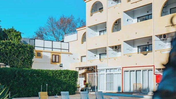 A multi-story hotel with a swimming pool, outdoor seating, and a well-maintained garden. - EiraSol by Umbral (Albufeira)