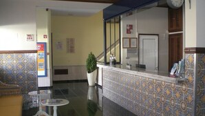 A hotel lobby with a reception desk, a staircase, and a seating area with a plant. - EiraSol by Umbral (Albufeira)